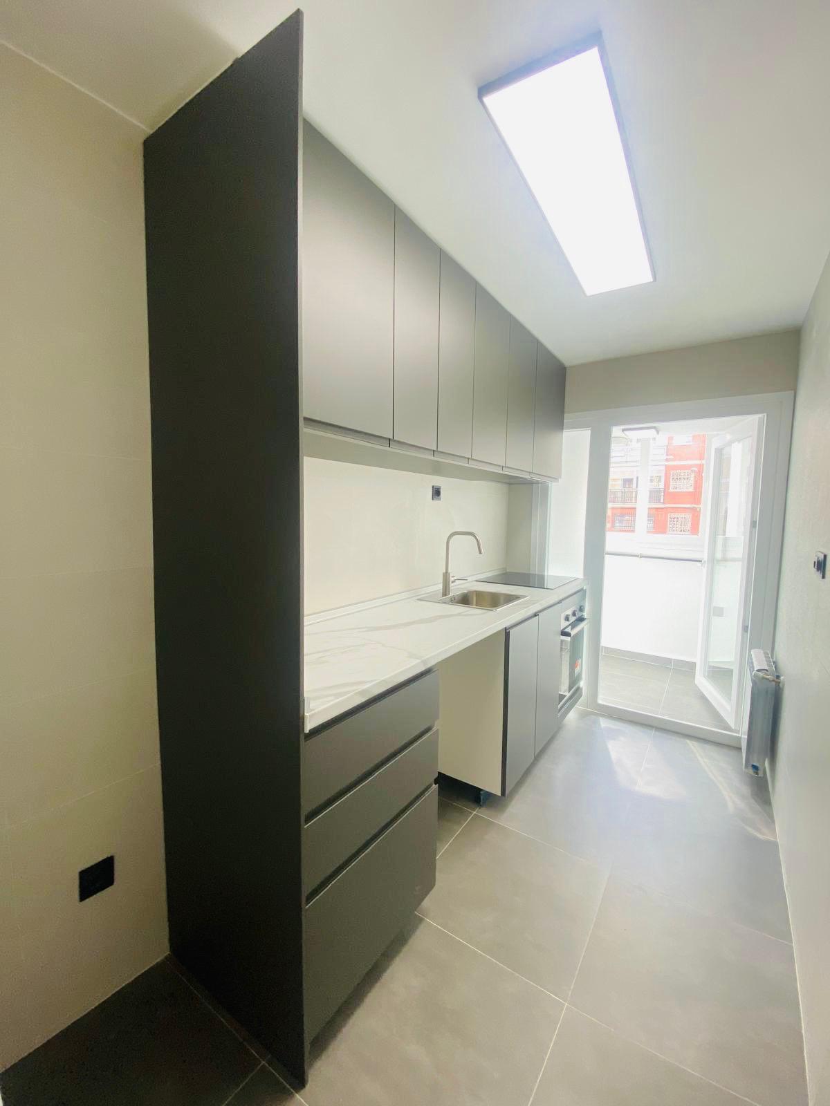 Cocina reformada con muebles oscuros